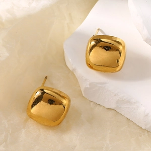 Close-up of polished gold square stud earrings with smooth edges on a textured background