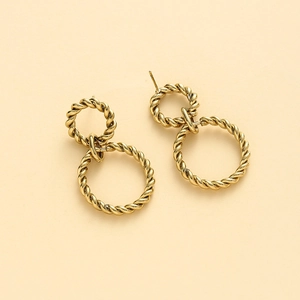 Macro detail of intertwined gold twisted hoop earrings with premium metallic texture