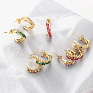 Detailed view of gold C-shaped earrings with intertwined rows of colorful zircon stones