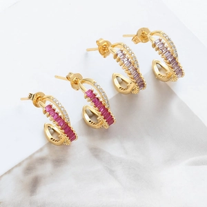Detailed view of dual-row gold earrings with emerald cut purple and rose red crystals