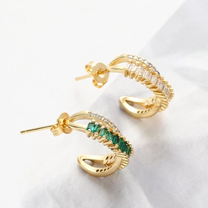 Detailed macro view of copper earrings with emerald green and white zirconia inlay