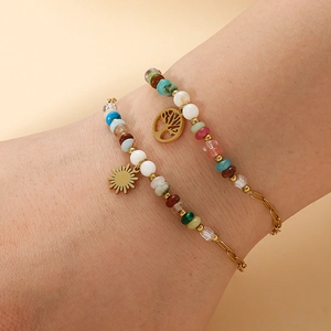 Bohemian tree of life and sun charm bracelets with colorful beads on a model's wrist