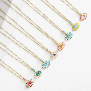 Détails de pendentifs œil grec en émail coloré avec pierres précieuses sur chaîne dorée