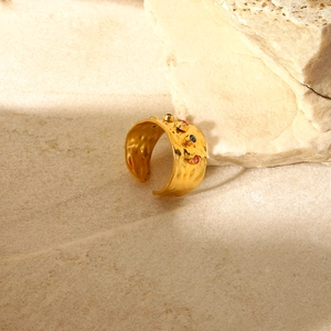 Macro view of gold hammered ring texture with embedded colorful zircon gemstones