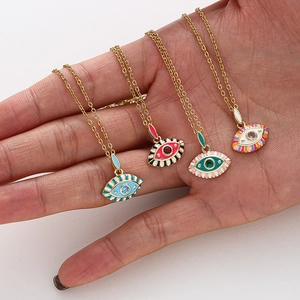 Vue détaillée de colliers pendentifs œil maléfique en émail coloré avec chaînes dorées