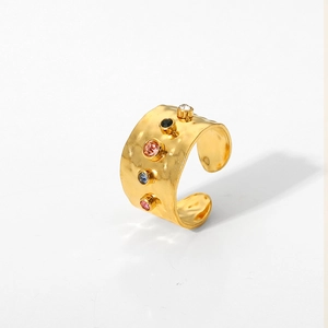 Detail of gold hammered texture ring featuring five colorful round cubic zirconia stones