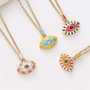 Détail de pendentifs œil maléfique colorés avec finition émail et pierres sur chaînes dorées