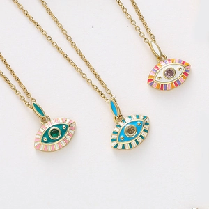 Vue macro de trois pendentifs œil en émail coloré avec zircons brillants au centre