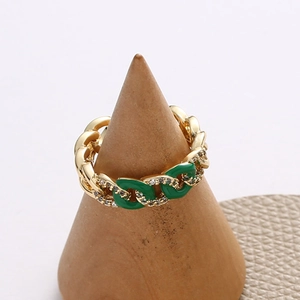 Close-up of gold chain ring with green enamel accents and micro-pave cubic zirconia