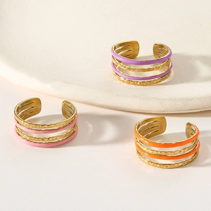Détail de bagues évidées en émail coloré en teintes violet rose et orange