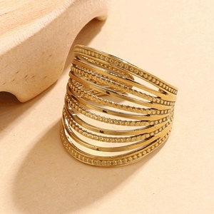 Macro shot of gold multi-layer stacked ring with textured beaded details on stainless steel