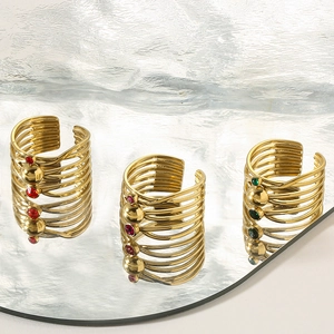 Detail of three-piece gold-plated steel rings featuring colorful zircon stones and retro style