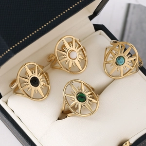 Golden oval stainless steel starburst rings set with black, white, green and blue stones
