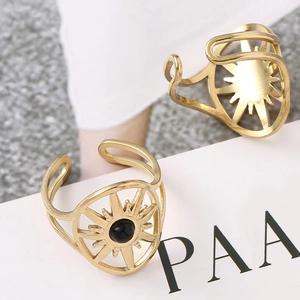 Close-up of gold starburst open rings with black stone inlay and sunburst texture