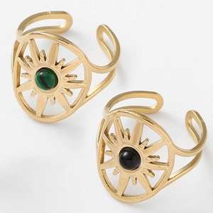 Detail of gold oval starburst rings with green malachite and black gemstone insets