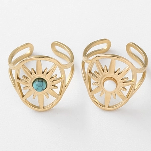 Close-up of golden wide-band starburst rings with turquoise and white stones