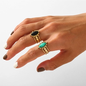 Ensemble de bagues dorées style bohème avec pierres onyx et turquoise sur la main
