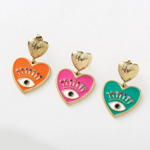 Vue détaillée de boucles d'oreilles cœur en émail coloré avec motif œil bleu de style boho