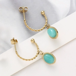 Détail des boucles d'oreilles torsadées dorées avec pendentifs en pierre turquoise