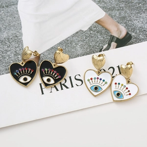 Détails de boucles d'oreilles en cœur avec motif œil émaillé et cristaux colorés