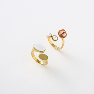 Detail of adjustable oval rings with white shell inlay and champagne gemstone accents