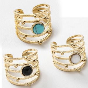 Detail of bohemian gold-plated multi-layer rings featuring turquoise and round stones