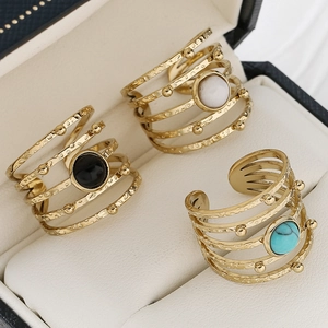 Adjustable gold spiral rings with natural stone insets on a premium jewelry display