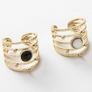 Detail of gold-plated multi-layer rings with textured hammered finish and natural stones