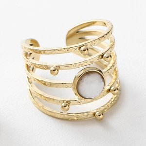 Close-up of gold-plated multi-layer ring with white gemstone and hammered texture
