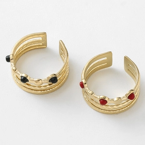 Detail view of gold multi-layer adjustable rings with red and black vintage beads