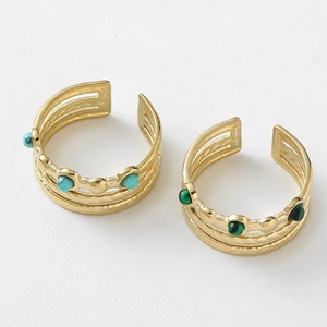 Close-up of gold layered rings with turquoise and green malachite gemstone inlays