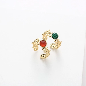 Close-up of gold star open rings featuring red and green malachite gemstone inserts