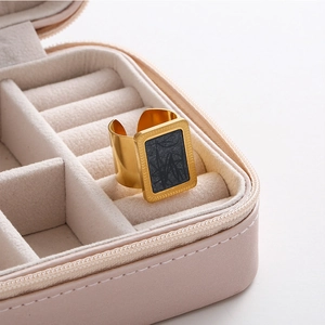 Elegant gold square signet ring with black marble inlay in a pink jewelry box