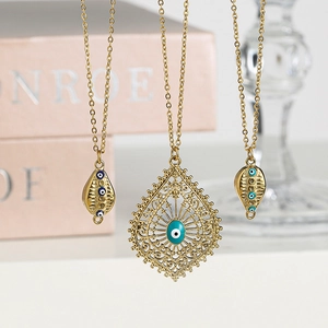 Colliers dorés avec pendentifs œil bleu et détails émaillés sur fond rose élégant