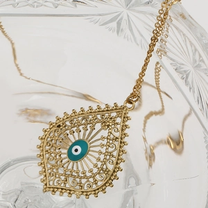 Détail macro du pendentif œil maléfique doré avec texture filigrane complexe