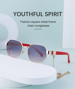 Close-up of polygon metal sunglasses with red temples and a detachable gold link chain