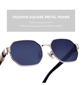 Detail view of stylish polygonal sunglasses with gold metal frame and dark grey lenses