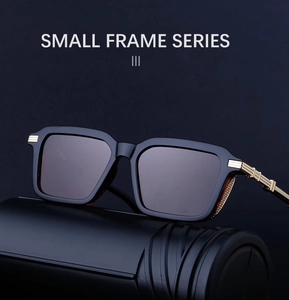 Detail of square black sunglasses showing golden parallel metal trim on the temple hinges