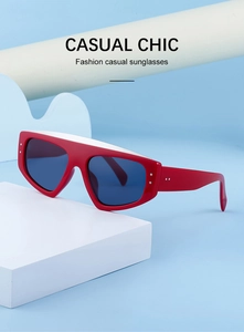 Détail de lunettes de soleil rouges et blanches avec verres bleus et accents métalliques