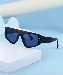 Détail de lunettes de soleil à monture noire, verres bleus et rivets argentés