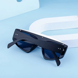 Détail de lunettes de soleil noires avec verres bleu foncé et rivets métalliques chic