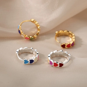 Chic S925 silver C-shaped hoop earrings with colorful enamel hearts on satin background