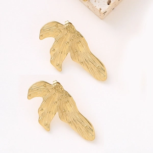 Macro view of gold French leaf earrings with intricate textured dot details
