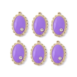 Macro view of six purple oval enamel pendants with gold edges and tiny sparkling zirconias