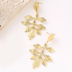 Detailed view of golden leaf-shaped earrings with intricate French pleated textures