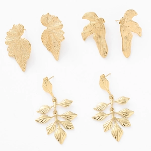 Detailed view of three pairs of gold leaf earrings featuring brushed metal leaf textures