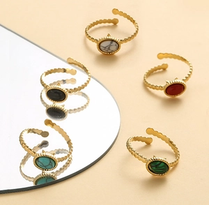 Detailed shot of five adjustable gold rings featuring colorful oval natural stone inlays