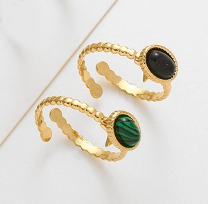 Detail of adjustable gold rings with oval black and green malachite stones and beaded bands