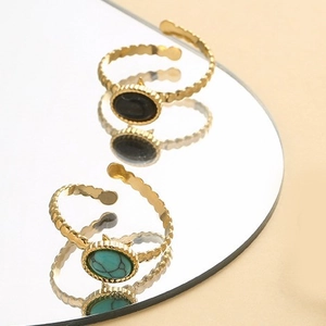 Minimalist oval natural stone gold rings in green and black with a mirror reflection