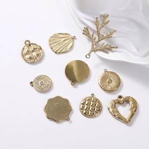 Gros plan de pendentifs géométriques en acier inoxydable doré et breloques texturées pour bijoux